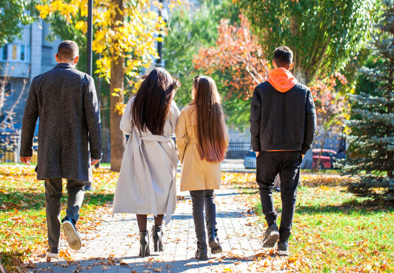 Back view, family walking in the autumn park