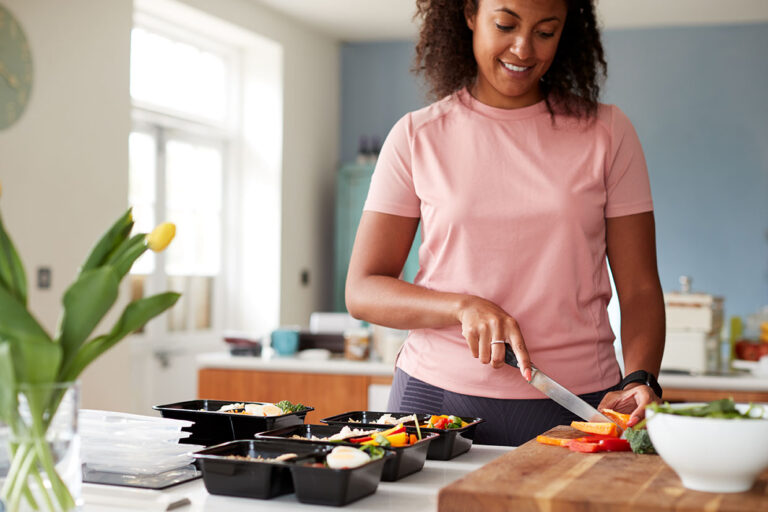 Woman Preparing Batch Of Healthy Meals At Home In Kitchen